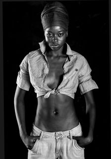 一张灰色照片，照片中的女子穿着短上衣，双手插在口袋里