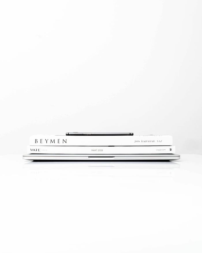 银色笔记本电脑，上面有两本书