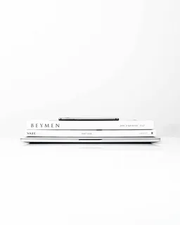 银色笔记本电脑，上面有两本书