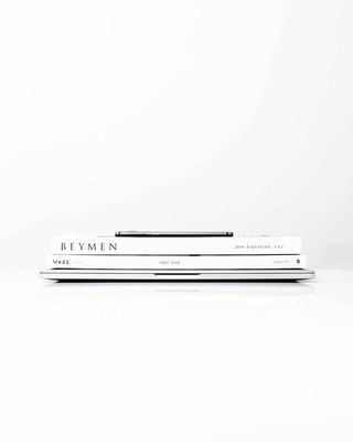 银色笔记本电脑，上面有两本书