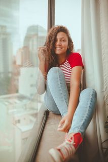 微笑的女人坐在窗台上的照片