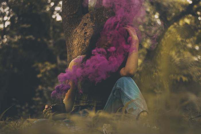 坐在粉红色烟雾中的女人