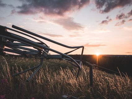 橙色日落期间，灰色钢铁农场机器在田地上