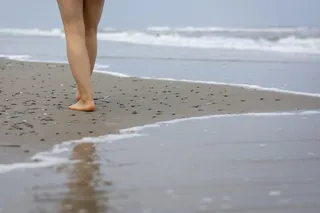 在海滩上行走的人的腿