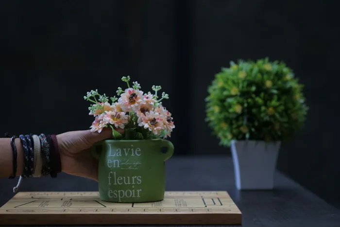 手持绿色陶瓷壶的人