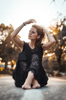 白天坐在水泥路附近的一名女子挽着头发 白天坐在水泥路附近的一名女子挽着头发