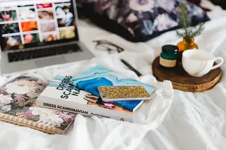 床上放满了枕头和带苹果小玩意的笔记本