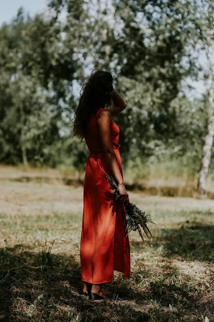 一个穿着红色连衣裙、在户外开着花的女人