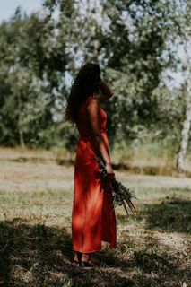 一个穿着红色连衣裙、在户外开着花的女人