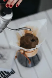 在Chemex过滤咖啡机里倒水的女人 在Chemex过滤咖啡机里倒水的女人