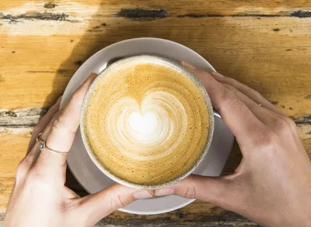 白色陶瓷杯上的棕色和白色拿铁咖啡