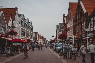 人们走在建筑物旁边的道路上