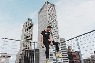 白天坐在灰色钢栅栏上的男人