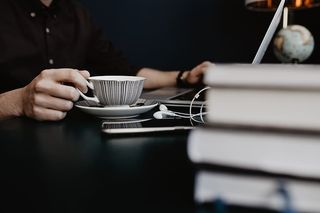 男性用笔记本电脑和一杯咖啡工作