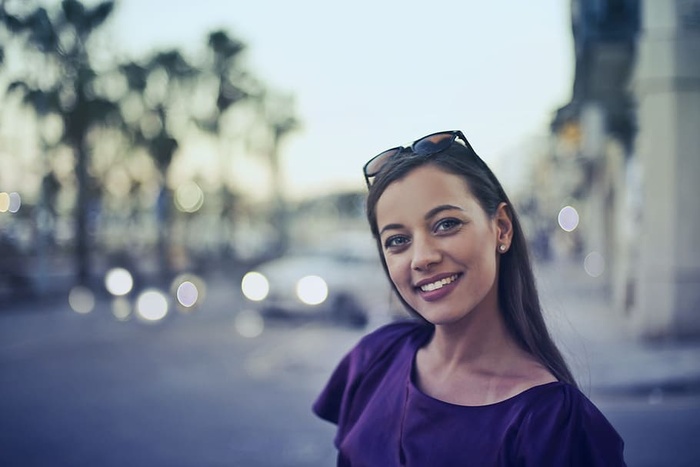 一位身穿紫蓝色连衣裙的金发女郎在户外摆姿势