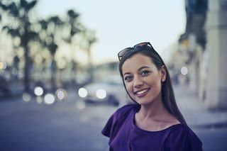 一位身穿紫蓝色连衣裙的金发女郎在户外摆姿势