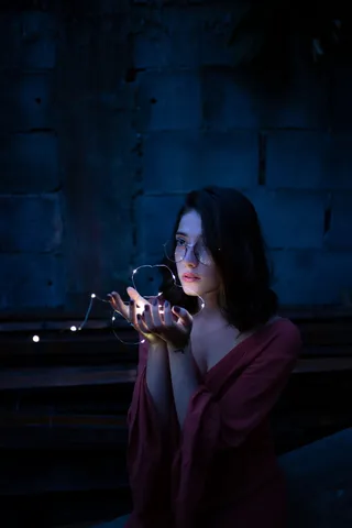 一名身穿红色连衣裙的女子手持细绳灯