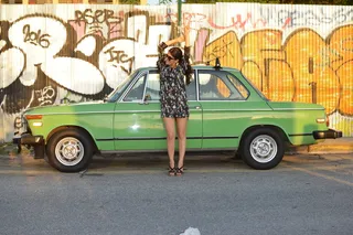 靠在停着的车上的女人