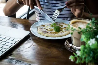 在咖啡店里吃蜂蜜煎饼的女孩