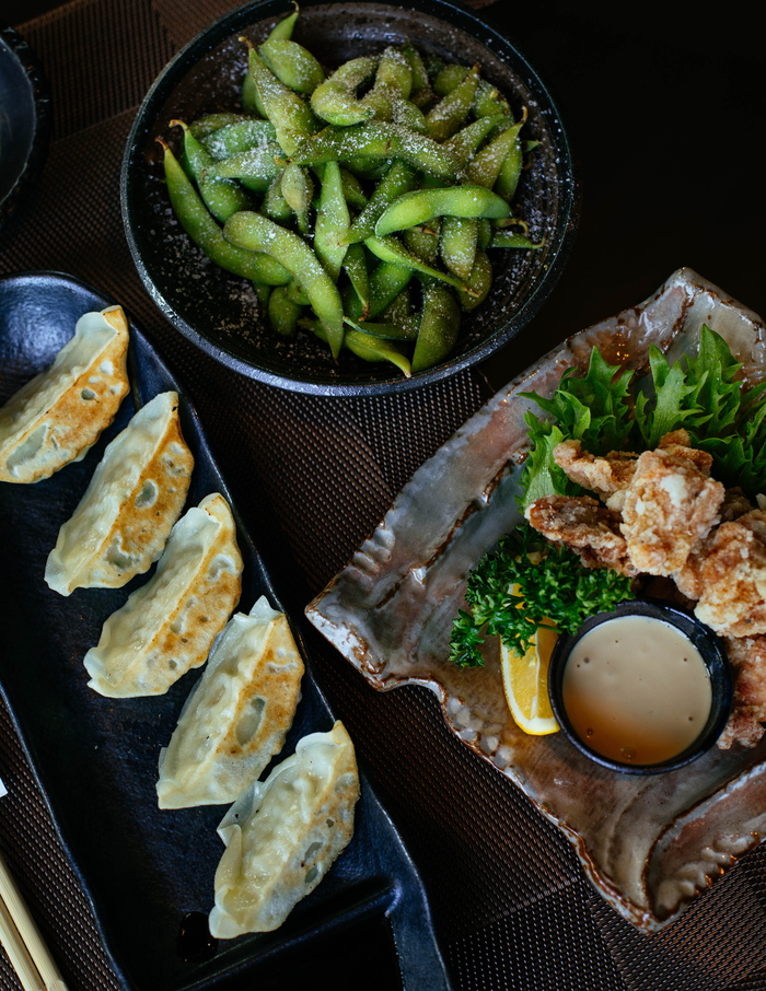 碗里放着大豆，桌子上放着煮熟的饺子和鸡肉