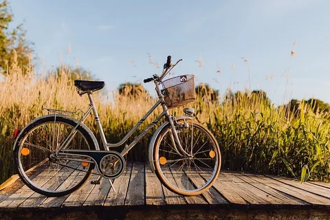 在明亮的夕阳下,在码头上放着篮子的自行车 在明亮的夕阳下,在码头上放着篮子的自行车