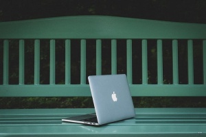 在白色木长凳上打开MacBook Pro