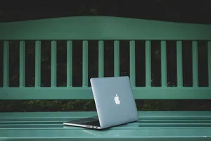 在白色木长凳上打开MacBook Pro