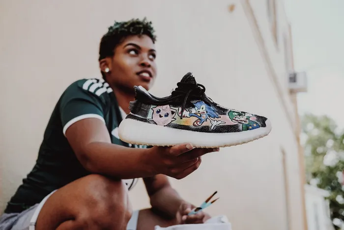 拿着黑白运动鞋的女人