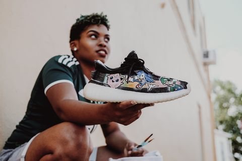 拿着黑白运动鞋的女人