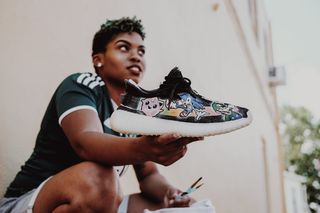 拿着黑白运动鞋的女人