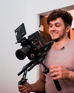 微笑的男子拿着相机和稳定器