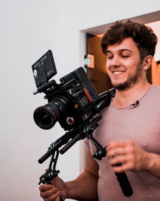 微笑的男子拿着相机和稳定器
