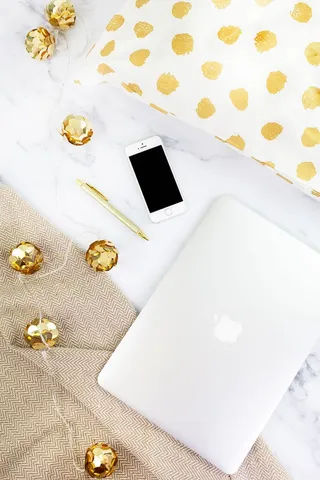 白色织物上的钢笔旁边的金色iPhone