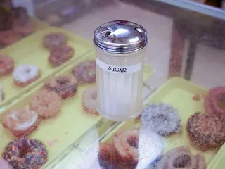 糖放在玻璃容器里，下面是甜甜圈。