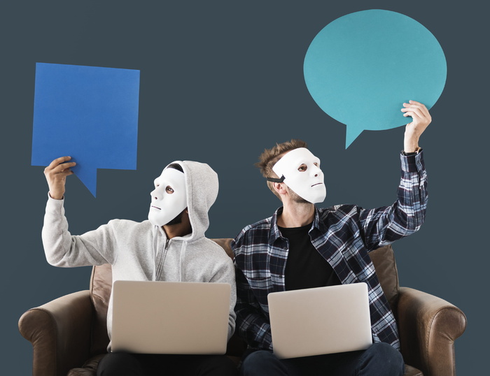 两名男子坐在棕色木沙发上使用白色笔记本电脑