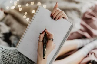 躺在床上的笔记本上写东西，里面有咖啡、蜡烛和姜饼