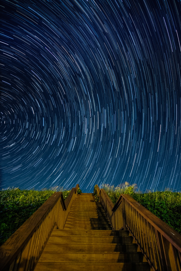 星空下青草旁的褐色水泥楼梯长曝光摄影