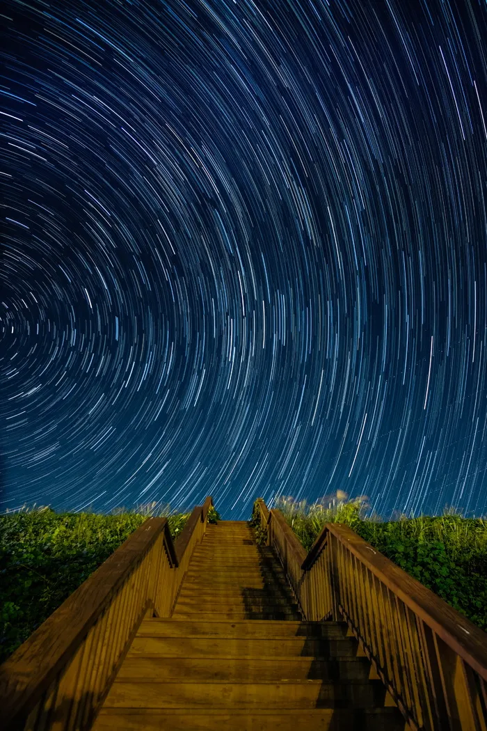 星空下青草旁的褐色水泥楼梯长曝光摄影