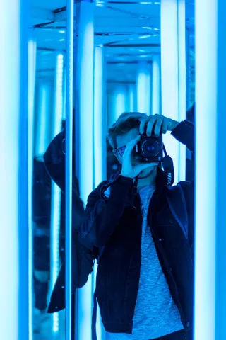 男子使用单反相机在镜子中拍照