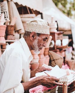 穿着白衬衫的男子拿着纸和铅笔
