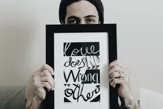 一个人拿着一个画框，里面写着“爱不会伤害别人”