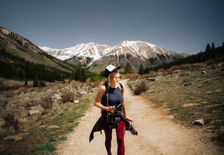 一名女子手持摄像机走在布朗路上