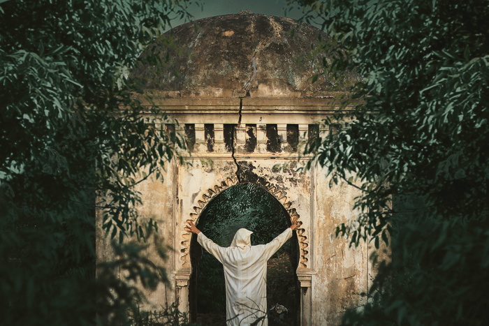 穿着白色连帽外套的人在白色拱门下