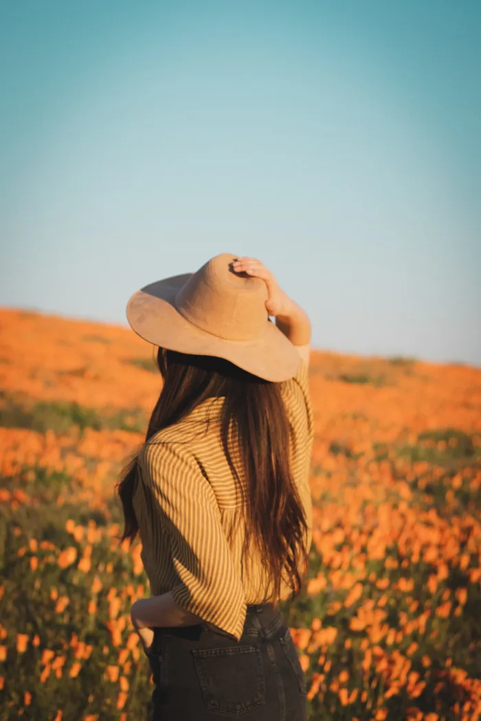 戴着白色帽子和米色高帽的女人