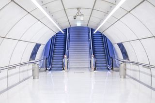 自动扶梯附近的灰色混凝土拱形走廊