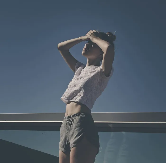 浅焦照片，一位身穿白色裁剪上衣T恤的女士