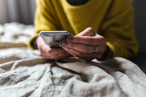 金发女郎在卧室里用笔记本电脑