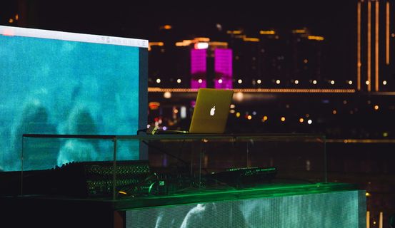 MacBook Air位于音频混音器附近的玻璃桌上