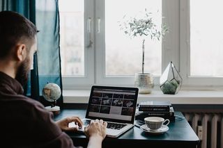 男性用笔记本电脑和一杯咖啡工作