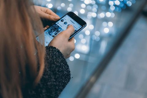 年轻女孩使用智能手机和Instagram应用程序